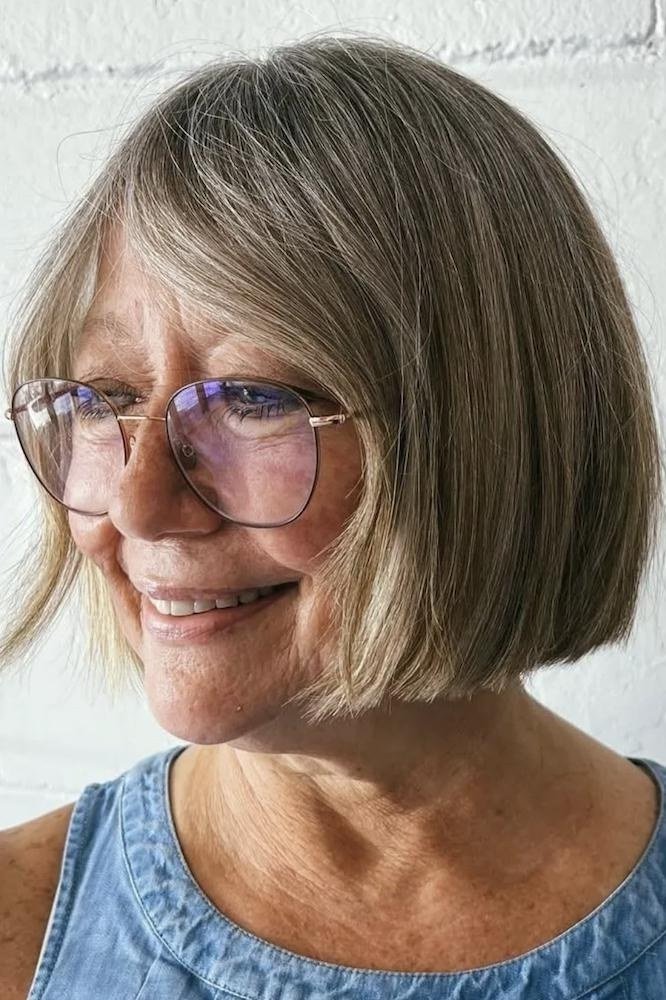 Ash-blonde side-swept short bob haircut for women over 60