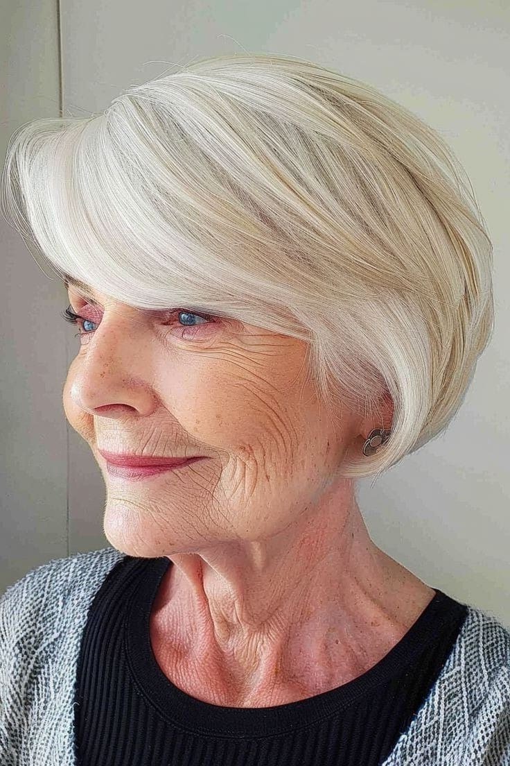 Platinum white sleek pixie bob with deep side part for older women