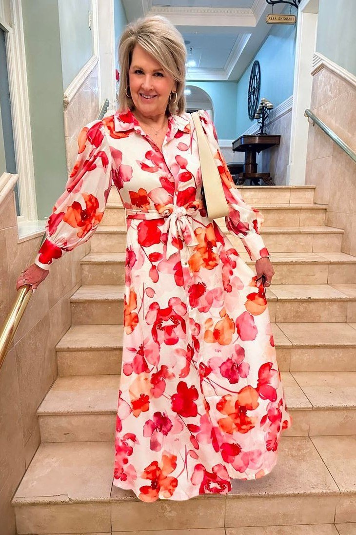 Bold coral floral maxi shirt dress for women over 60: large red blossoms, long sleeves and a self-tie waist
