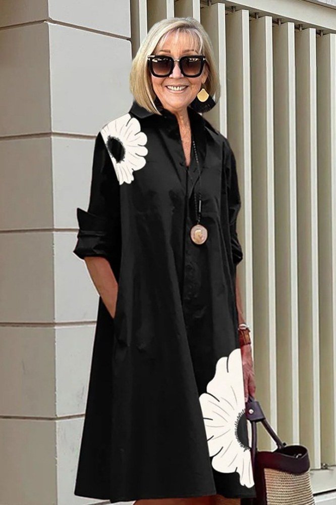Black daisy-print maxi shirt dress for women over 60: oversized white daisies on black with long sleeves and sunglasses