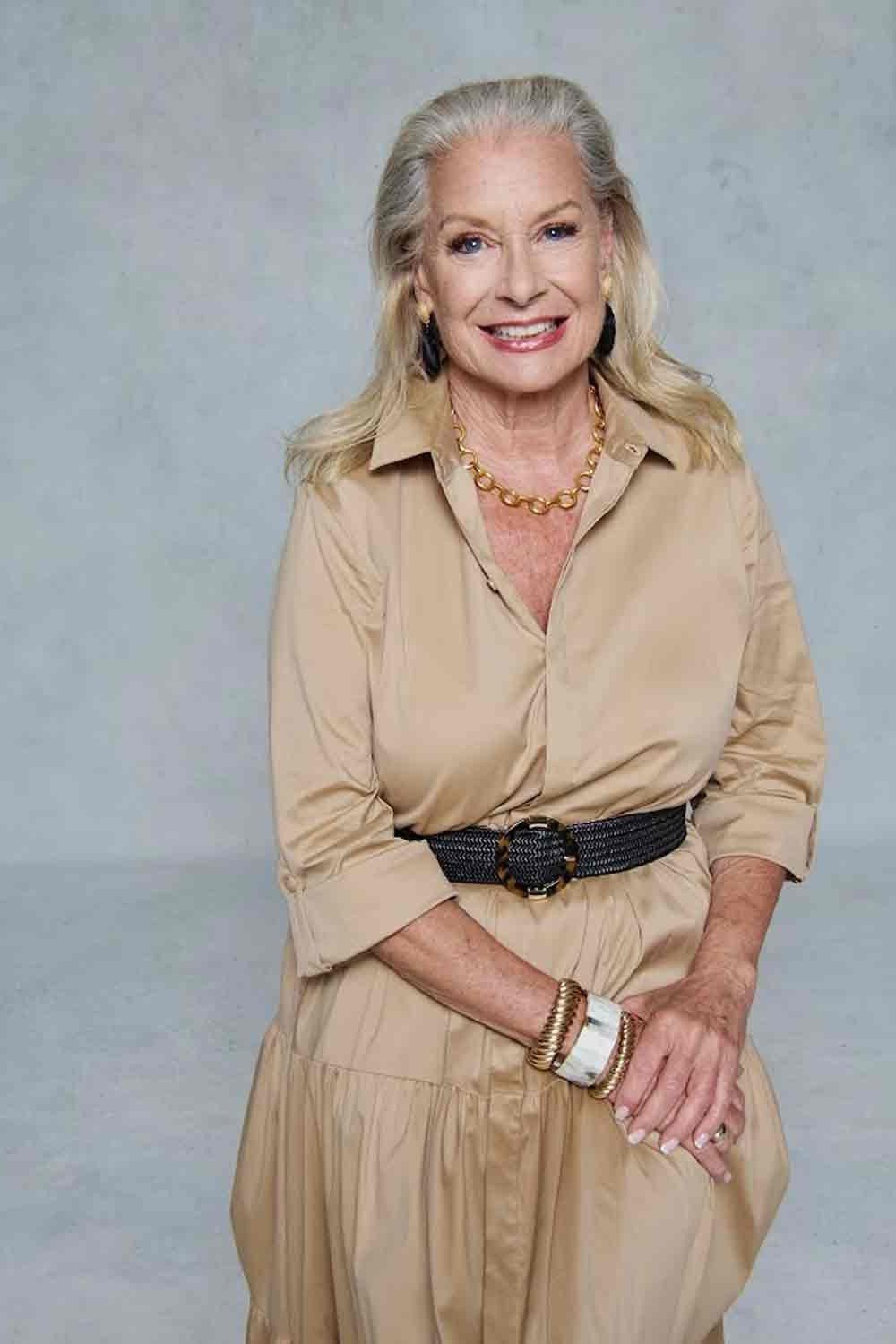Beige maxi shirt dress for women over 60: flowing long-sleeve style with a black woven belt and gold necklaces