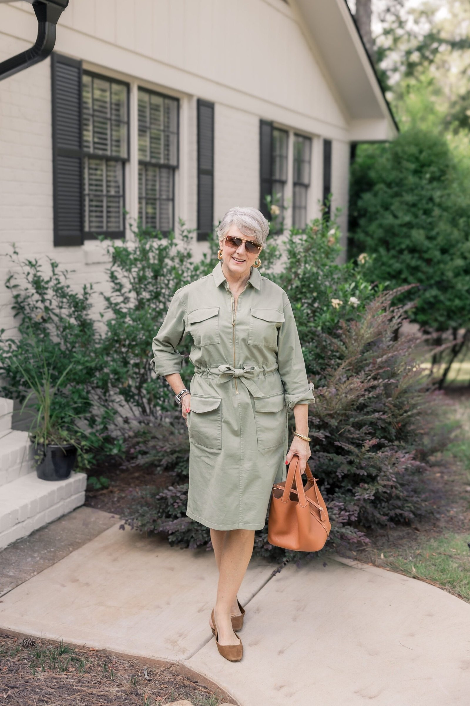 Sage safari shirt dress for women over 60: light green with a tie belt and chest pockets with a tan handbag