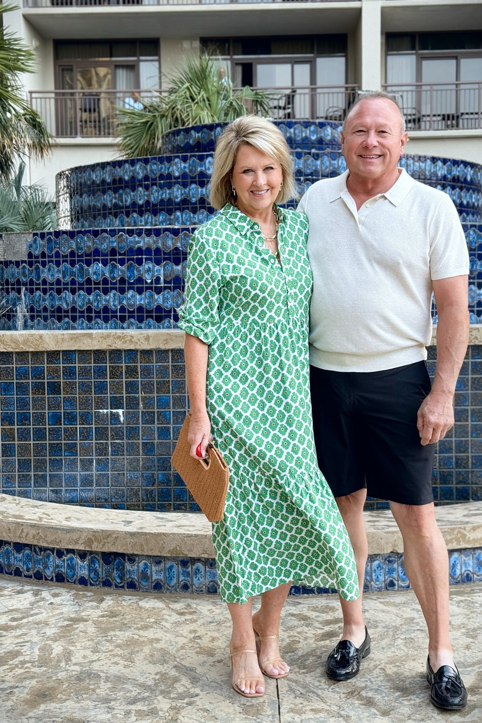 Green patterned midi summer dress for older women by a fountain