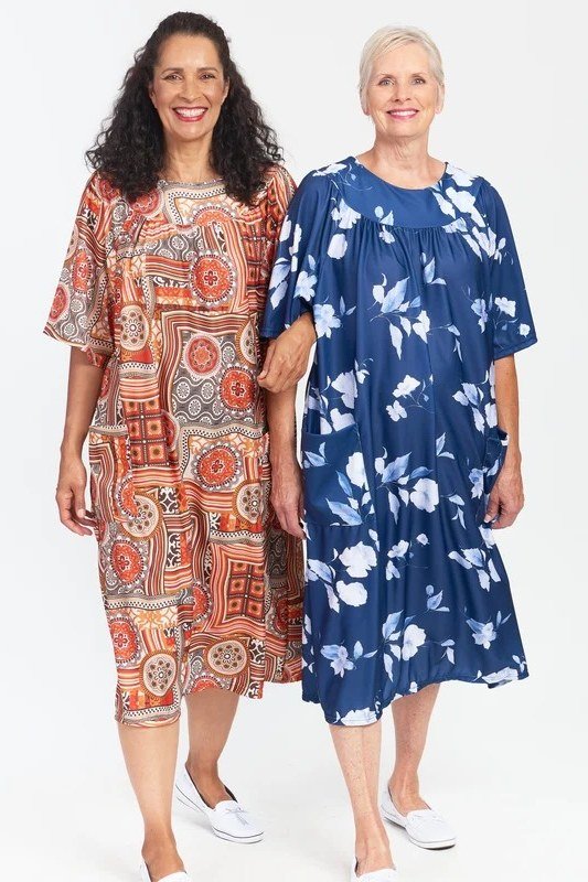 Two older women in blue floral and orange printed summer dresses