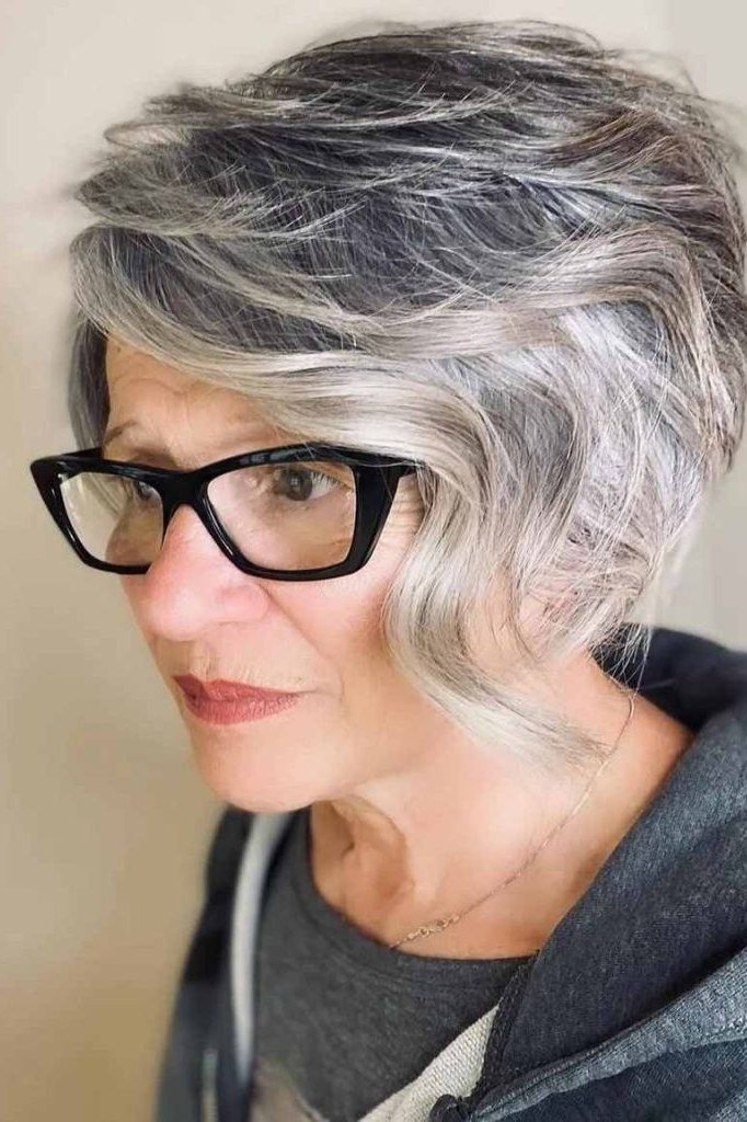 Silver shaggy bob with glasses on a woman over 60 in three-quarter front view