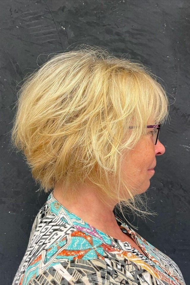 Blonde shaggy bob on a woman over 60 in side profile