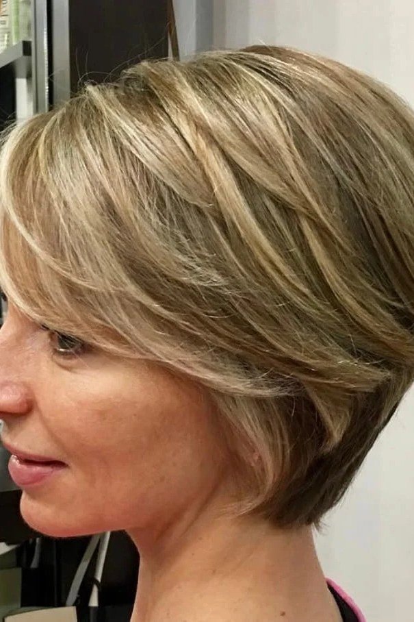 Shaggy pixie bob hairstyle for women over 60: honey-blonde shaggy pixie bob, salon, older woman, side view