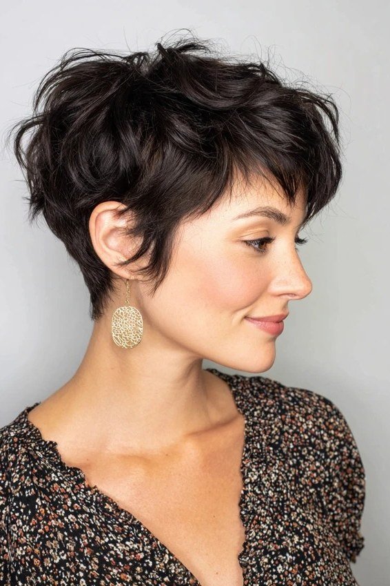 Shaggy pixie bob hairstyle for women over 60: black shaggy pixie bob, textured crown, mature woman, side view
