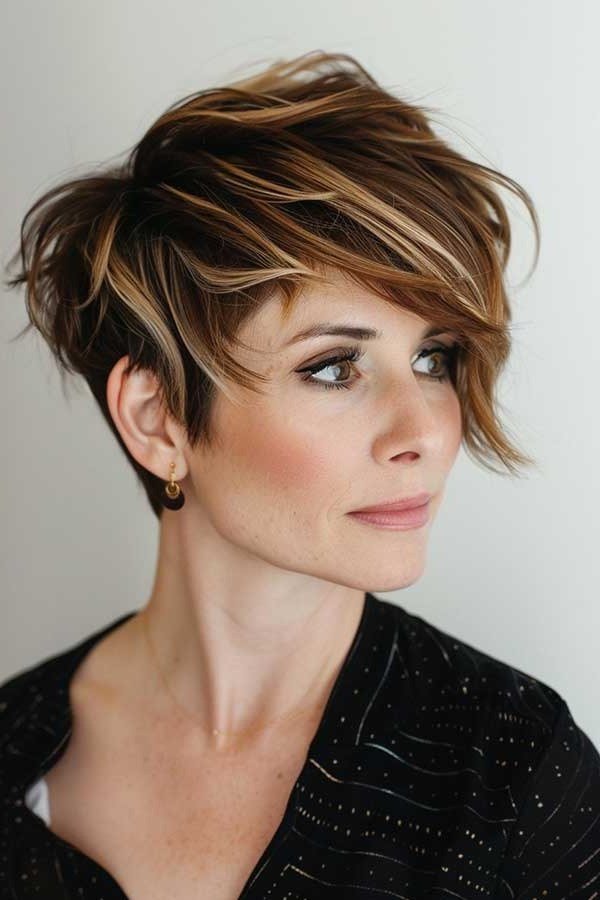Shaggy pixie bob hairstyle for women over 60: highlighted brown asymmetrical pixie bob, piecey, mature woman, front 3/4 view