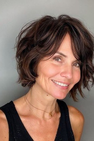 Dark shaggy bob, front smiling - shaggy haircut for women over 50 with fine hair