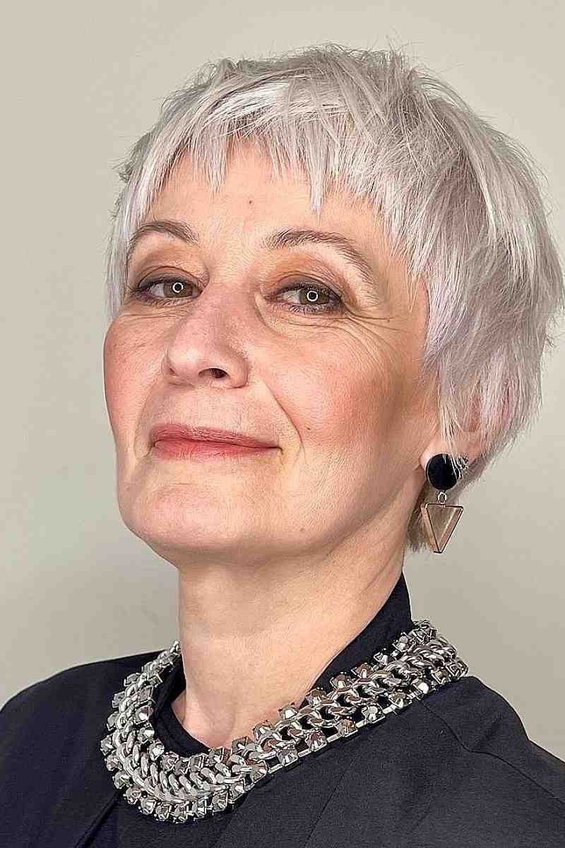 Bright white pixie haircut with wispy fringe on older woman