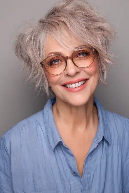 Layered silver pixie haircut with wispy bangs and glasses