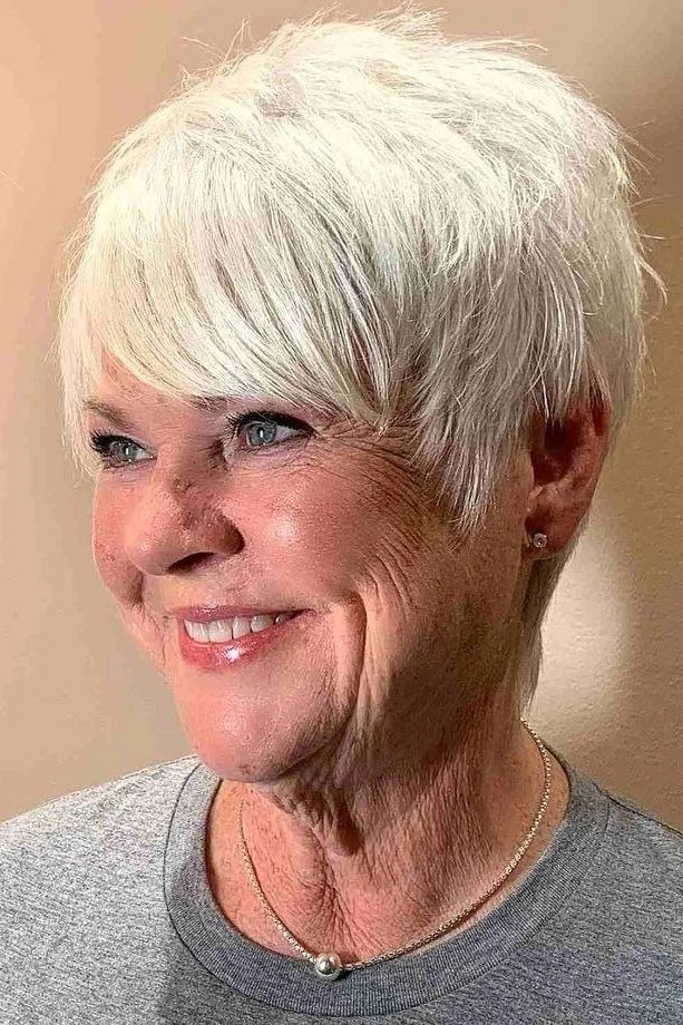 Silver pixie haircut with side-swept bangs for women over 60