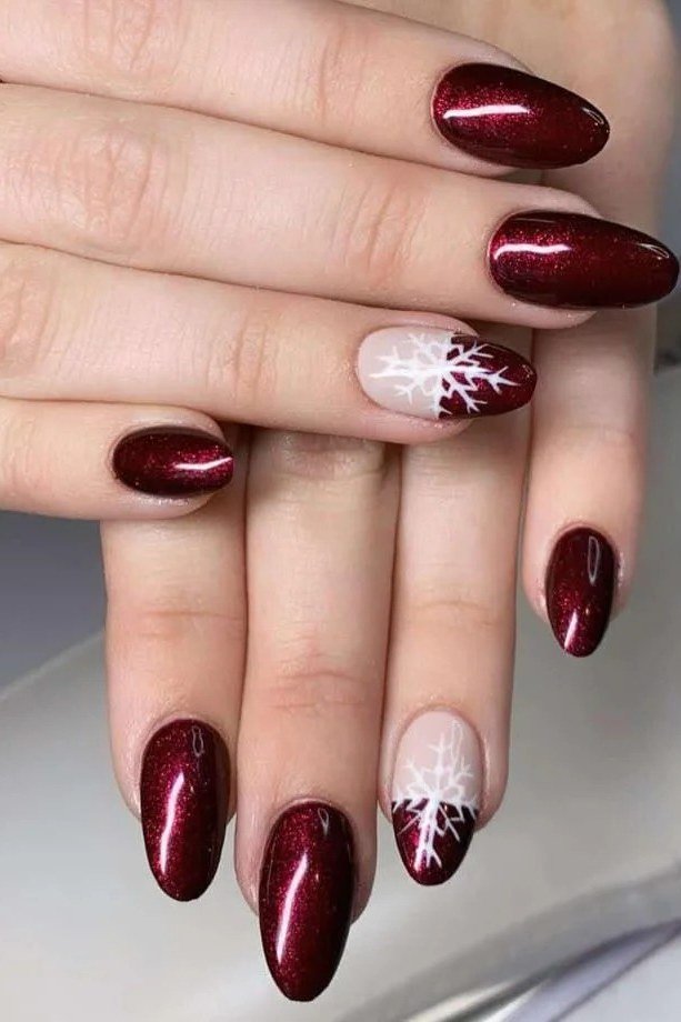 Dark red nails with white snowflake accent nail art, elegant winter manicure
