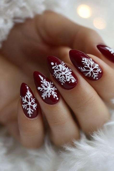 Burgundy nails with white snowflakes and cozy fur texture accent nail, winter look