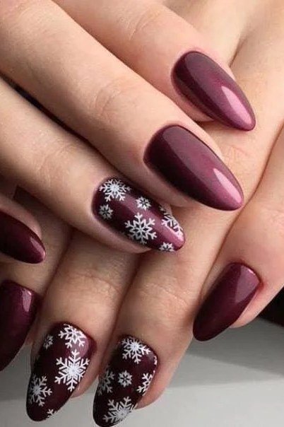 Deep plum nails with white snowflake nail art, rich winter manicure for mature hands