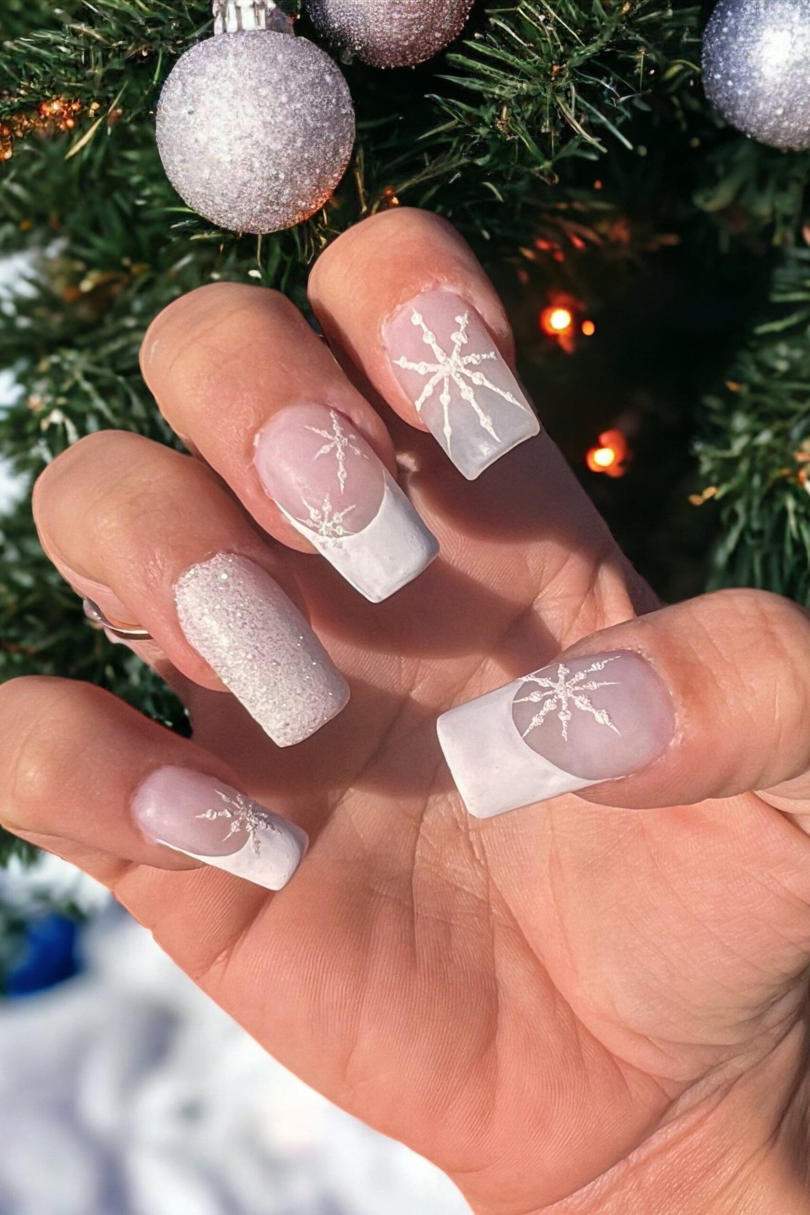 Soft pink nails with white snowflake nail art, fresh wearable winter manicure
