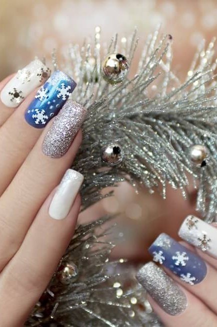 Icy blue nails with silver snowflake nail art, crisp frosty winter manicure