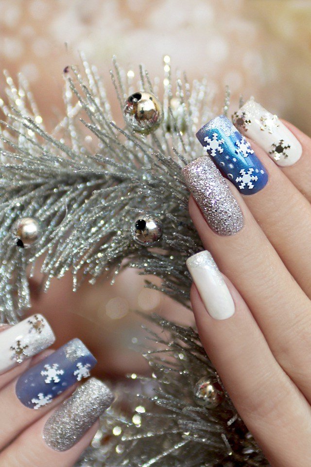 Blue nails with silver tinsel stripes and white snowflakes, fun holiday nail art