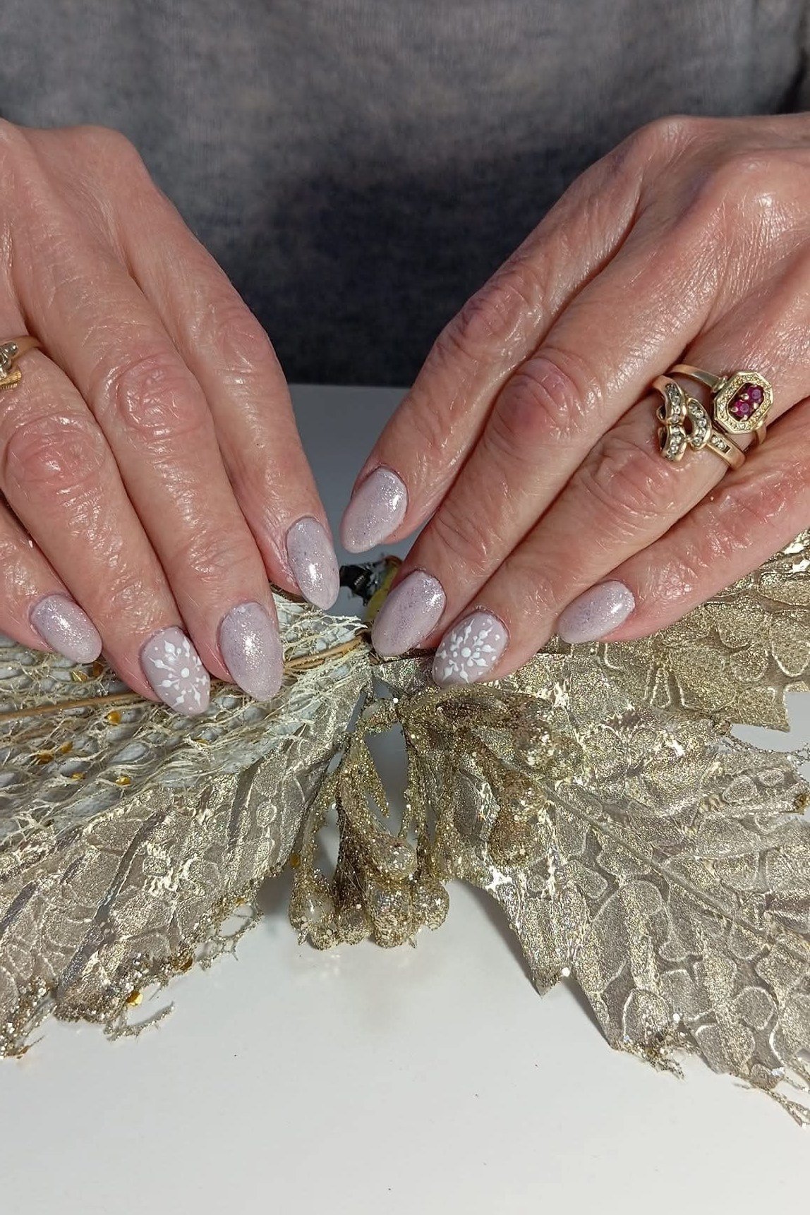 French manicure with tiny snowflakes near tips on mature hands, timeless winter look