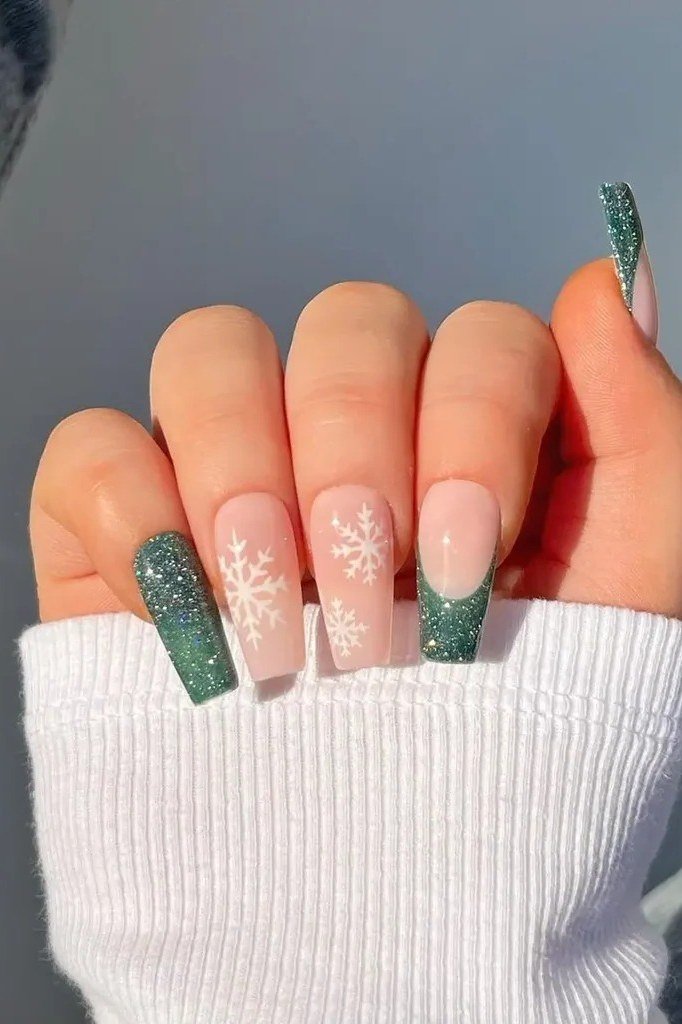 Pink and green glitter nails with white snowflakes, playful holiday nail art