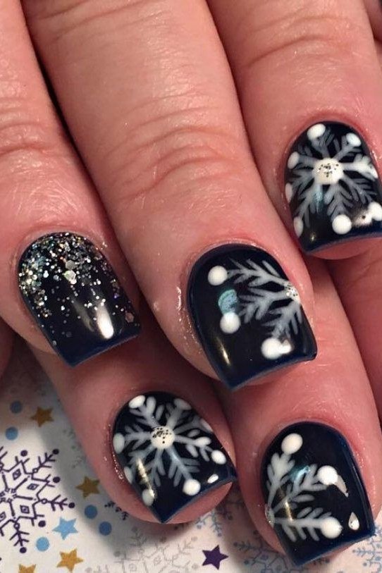 Jet-black nails with stark white snowflakes, high-contrast winter nail art