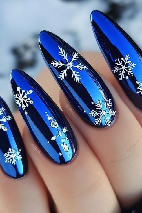 Chrome blue nails with white snowflakes, futuristic icy winter manicure