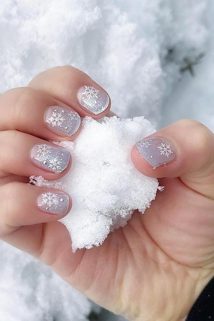 Purple nails with white snowflake snowball dots, playful winter nail art design