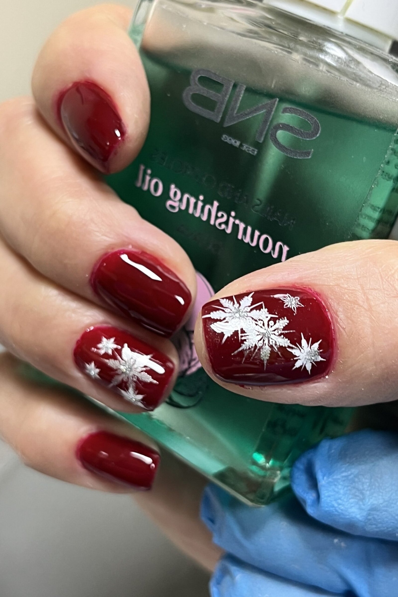 True red nails with elegant white snowflakes, timeless classic winter manicure