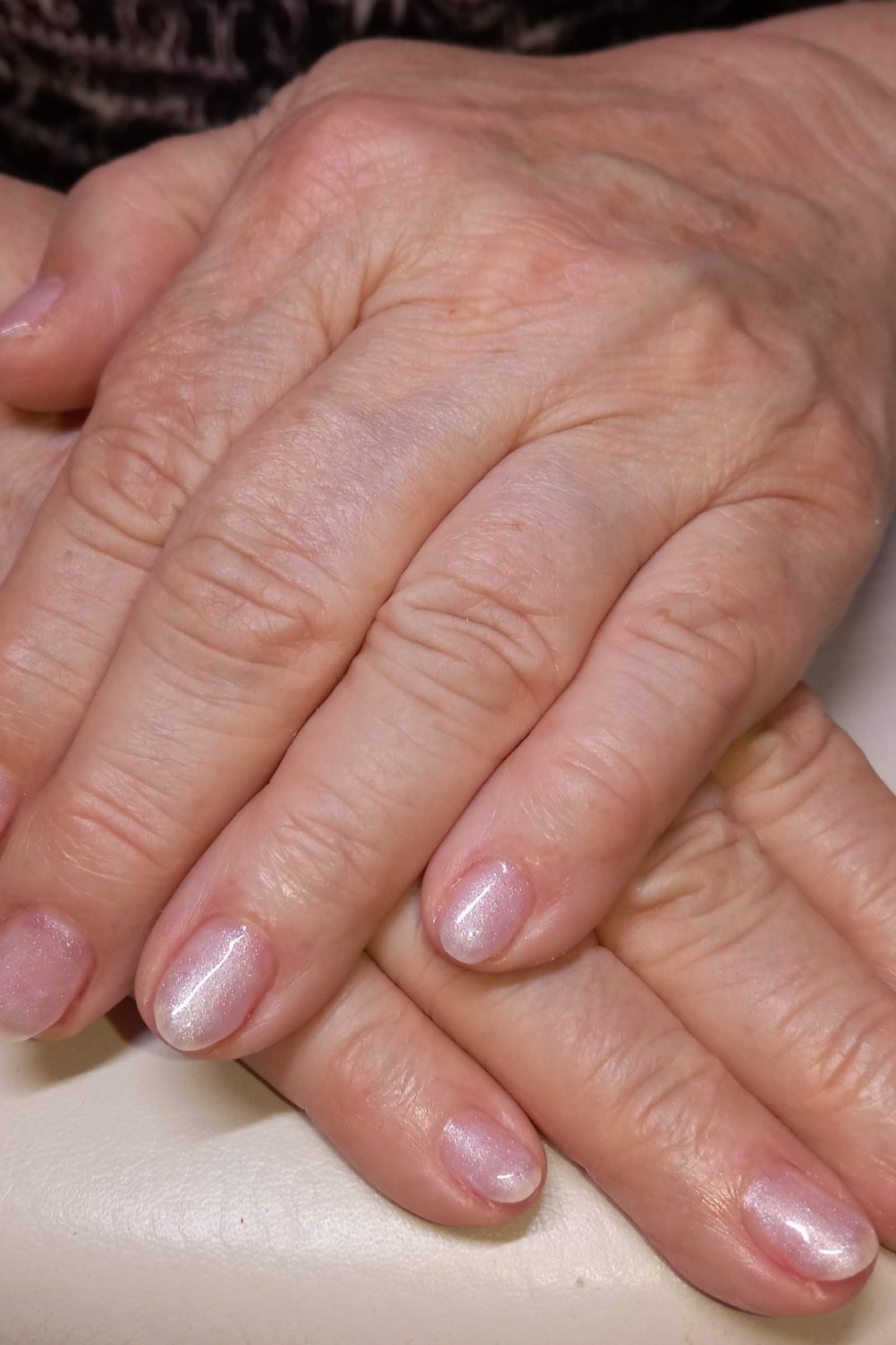 Pearly pink manicure on mature hands