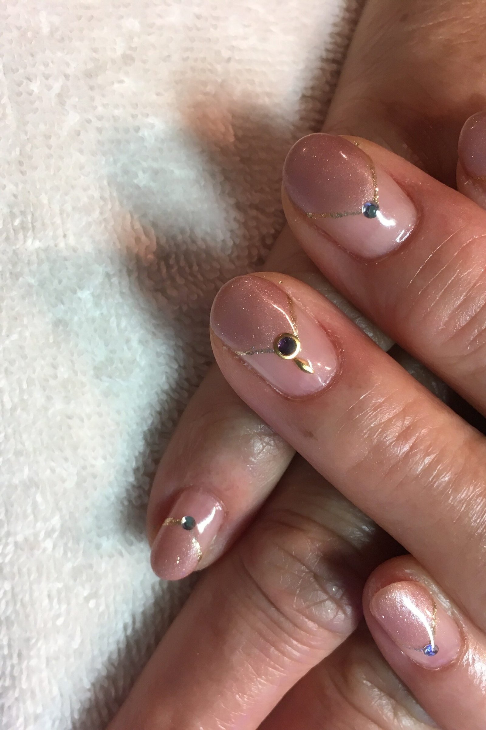 Sheer pink nails with tiny dot accents on mature hands