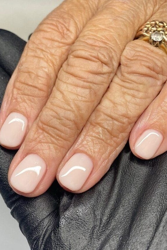 Ivory cream nail polish on mature hands