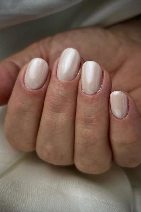 Pearly white nail polish on mature hand