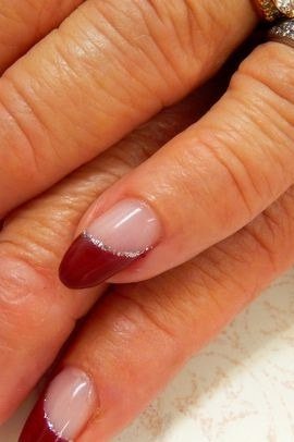 Red French tip nails on sheer base, mature hands