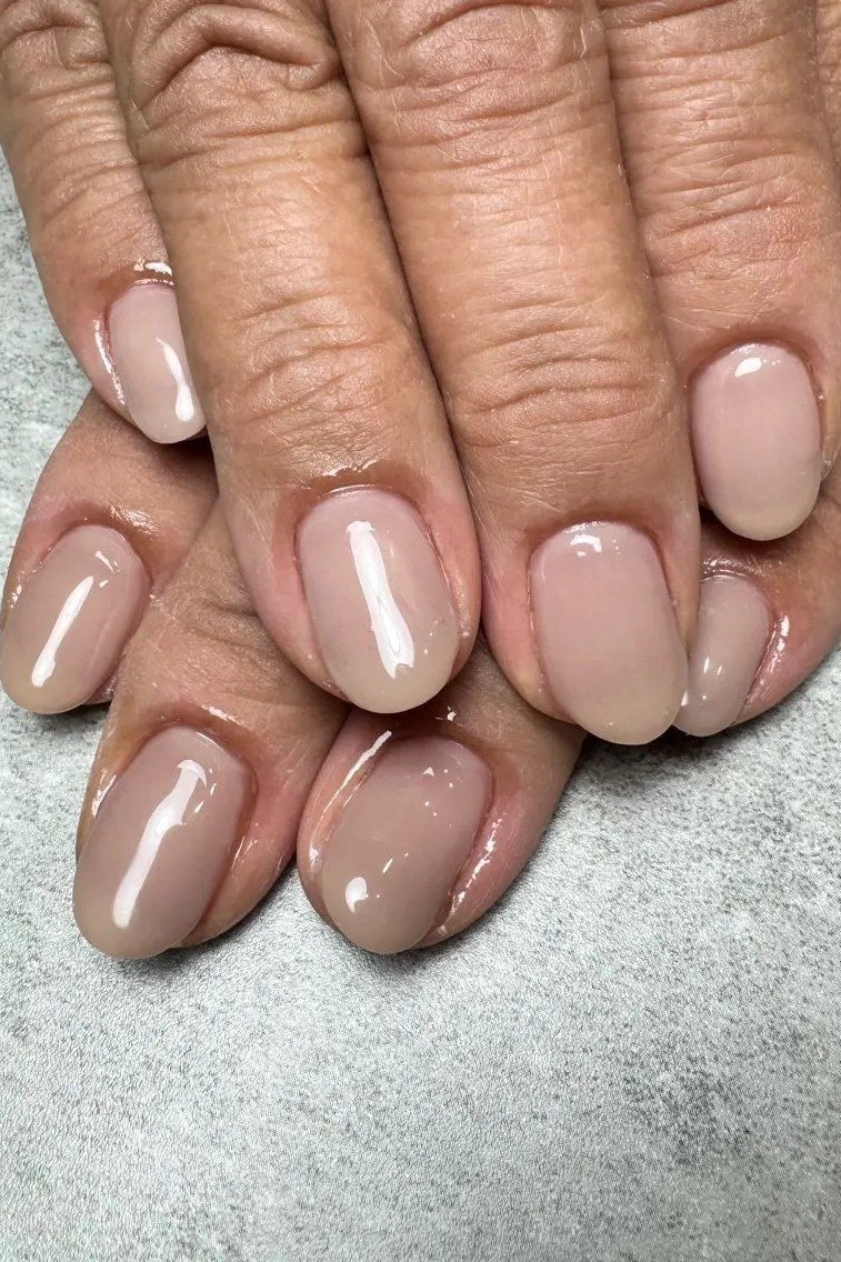 Mauve taupe glossy nails on mature hands