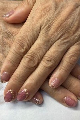 Mauve pink shimmer nail polish on mature hands