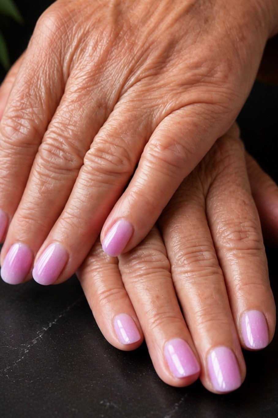 Lilac pink ombre nail polish on mature hands