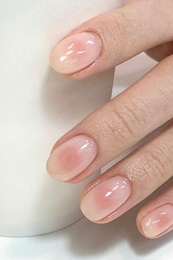 Sheer Pink Holding a Cup - simple pink nail idea for women over 50