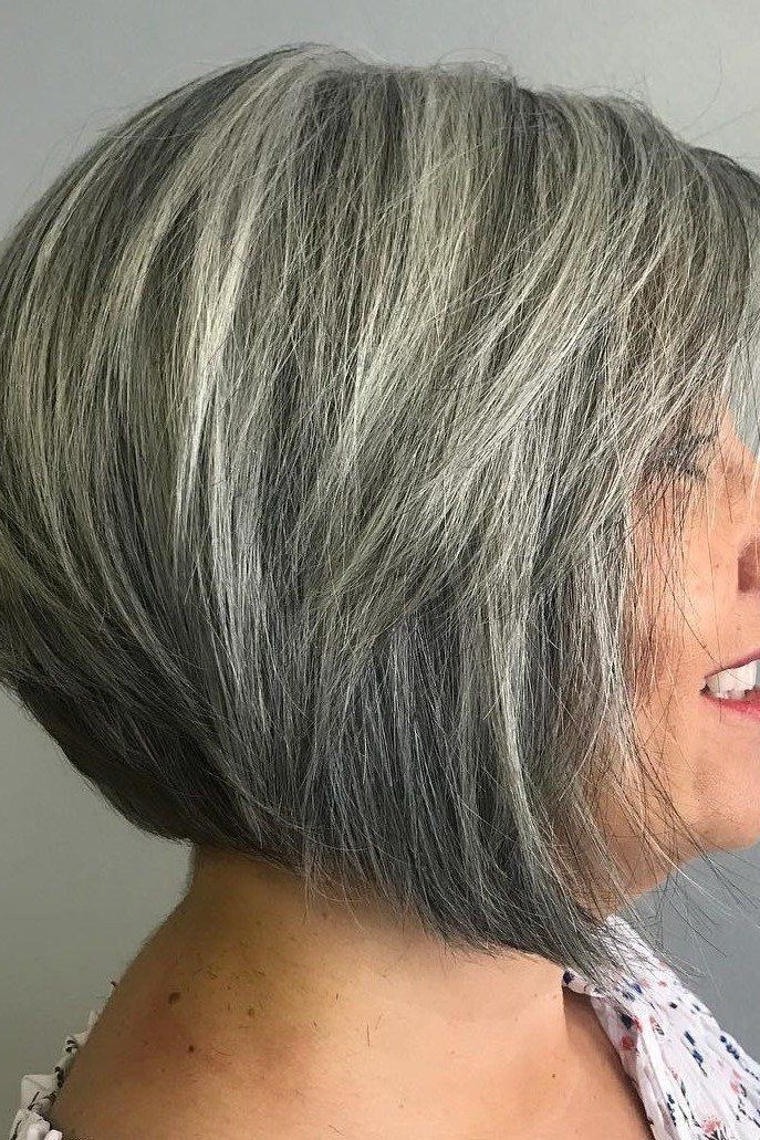 Gray green angled stacked bob haircut for women over 60, side view