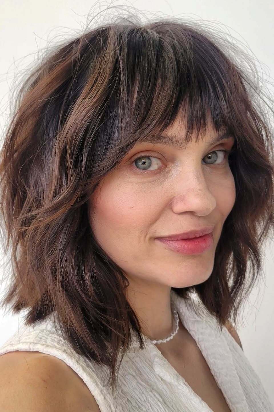 Dark brown shaggy bob with bangs for women over 60, front view