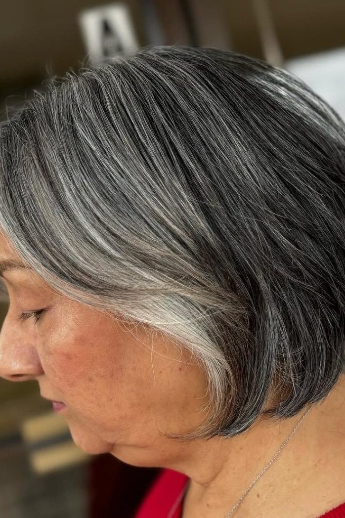 Dark gray black stacked bob haircut for women over 60, side profile view