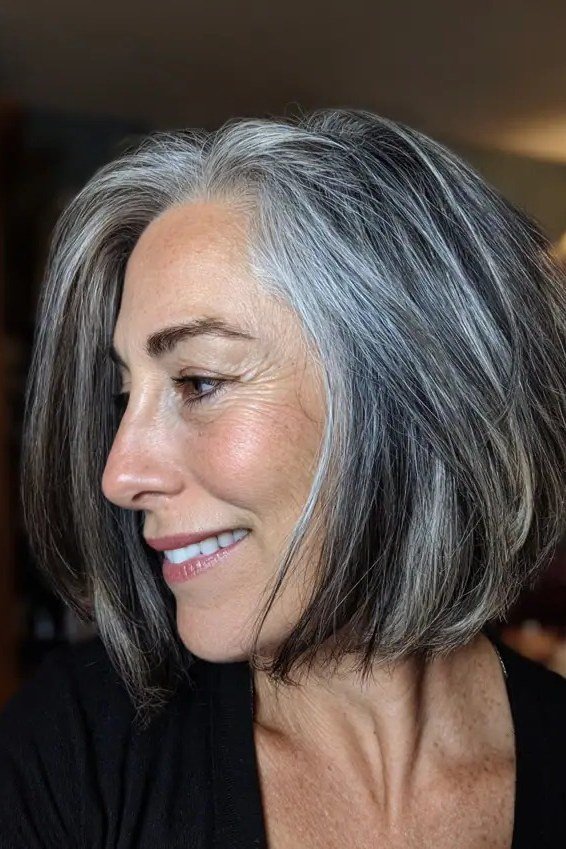 Silver-grey layered side profile, smiling - inverted bob haircut for women over 60