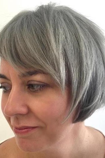 Grey side-swept bob with bangs, three-quarter - inverted bob haircut for women over 60