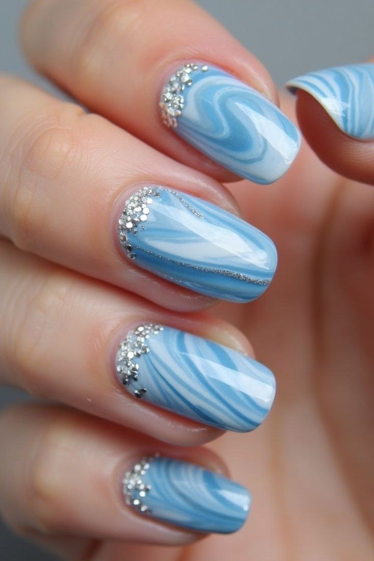 Blue and white watercolor marble nails with silver glitter at cuticles, summer nail art