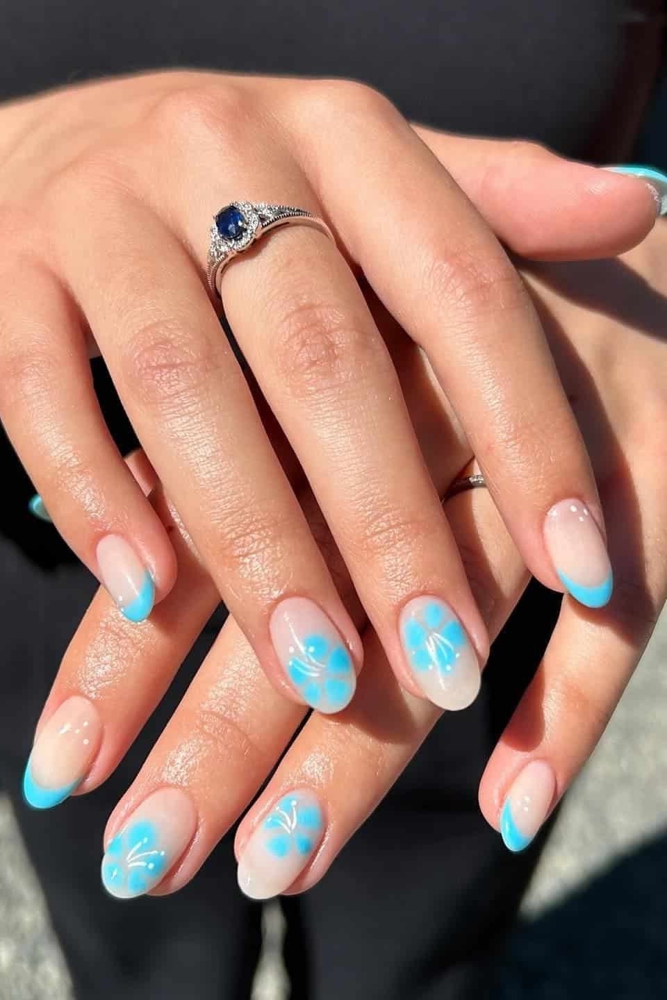 Nude nails with turquoise French tips and turquoise daisy nail art, summer floral nails