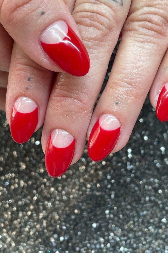 Red almond nails with sheer nude half moon at cuticles, elegant reverse French nails
