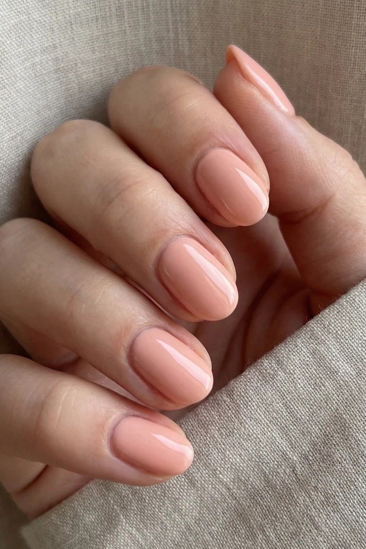 Soft peachy nude oval nails with glossy finish, natural summer nails for women over 40