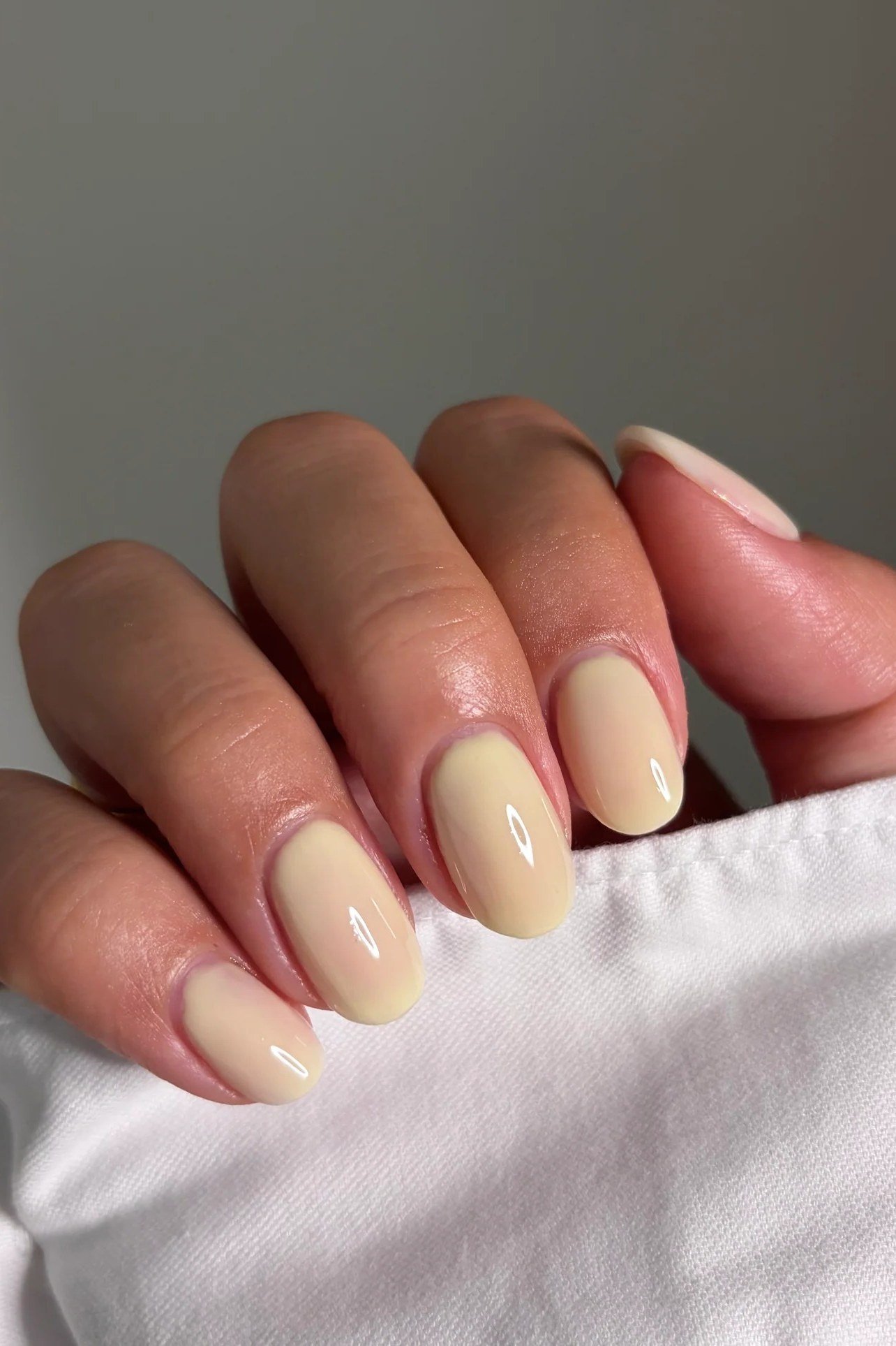 Pale butter yellow cream short nails with glossy finish, soft summer yellow nails