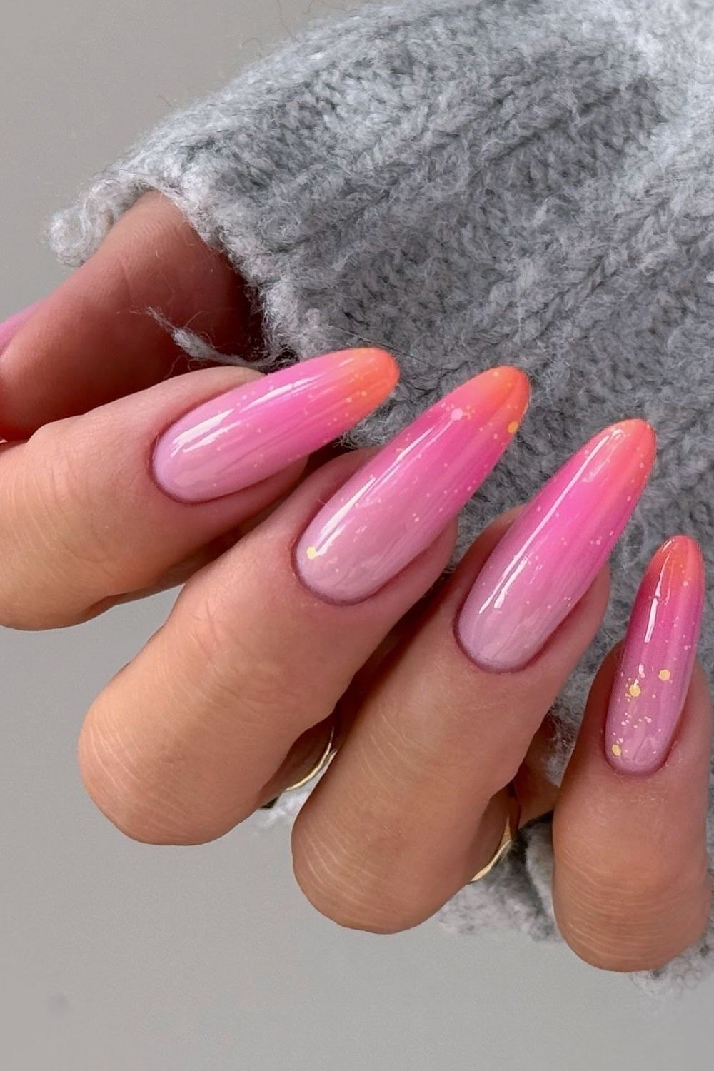 Pink to peach ombre long almond nails with gold glitter flecks, sunset summer nails