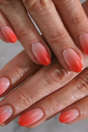 Coral pink ombre short nails fading from nude to coral tips, soft summer ombre nails